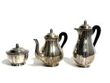 three silver teapots and a silver teapot on a white surface