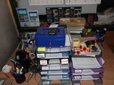 un bureau encombré, sur lequel se trouvent de nombreuses fournitures de bureau