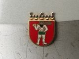 a picture of a red and white badge with a man holding a baseball bat