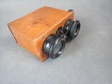 an old wooden box with two black wheels and a wooden box with two black wheels