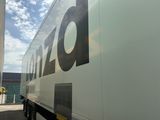 un grand fourgon blanc garé devant un immeuble