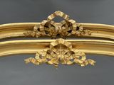 un cadre doré orné d'un motif floral sur le dessus