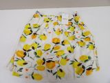 skirt with yellow flowers and green leaves on it on a white surface