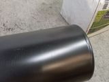 a black cylinder sitting on the floor next to a couch