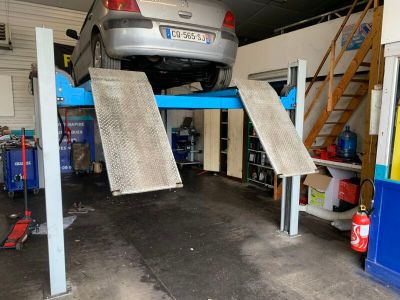 une voiture posée sur un pont élévateur dans un garage