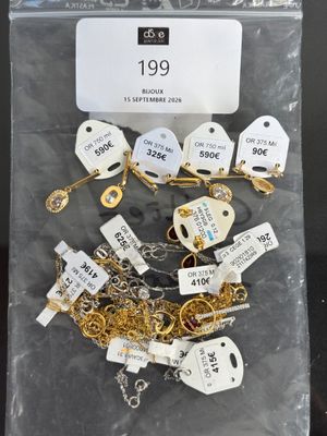 a bag of gold and silver necklaces with tags on them