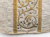 a close up of a white and gold cloth with gold trim