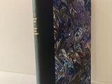 Le livre est posé sur une table, à côté d'une tasse de café.