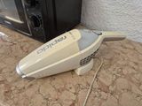 a white and gray vacuum sitting on a counter next to a toaster oven