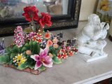 a vase with flowers on a table next to a statue of an angel