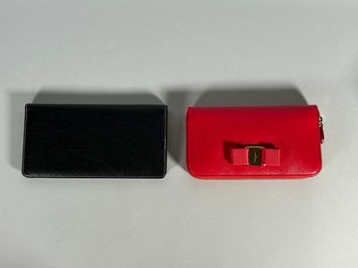 two pieces of red and black purses on a white table