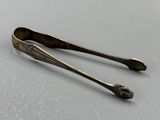 une paire de cuillères anciennes en argent posées sur un support gris