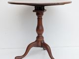 an old wooden table with a round top on a white background