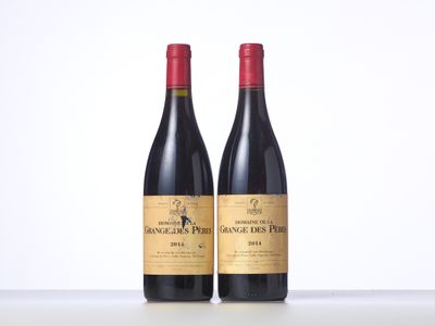 two bottles of red wine sitting on top of a table