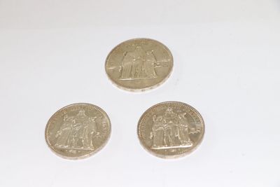 three coins are sitting on a white surface next to each other