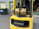 a yellow forklift truck parked in front of a building