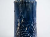 a blue vase that is sitting on a white surface