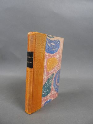 an orange book sitting on top of a table next to a gray background