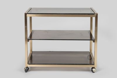 une table d'appoint en laiton et en verre, dotée de trois étagères et montée sur roulettes