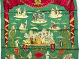 une image représentant un foulard en soie vert et rouge orné d'un motif représentant des personnes