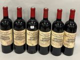 six bouteilles de vin rouge sont alignées sur une surface blanche