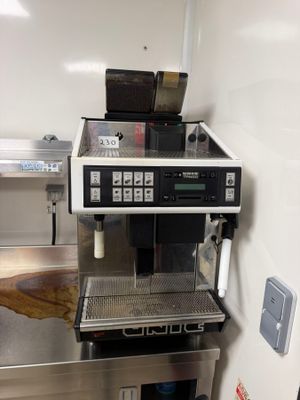 une machine à café posée sur un plan de travail en inox
