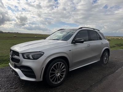 a silver mercedes suv parked on the side of a road