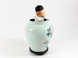 a small figurine of a man sitting in a vase
