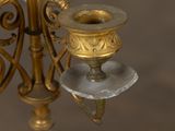 a gold candle holder with a candle on top of it