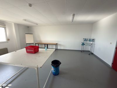 une pièce avec une table et un seau posé par terre