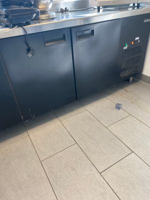 a kitchen with a stainless steel counter top and a black refrigerator