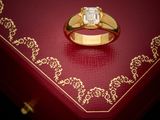an image of a gold ring sitting on top of a red box