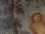 a painting of a cupid holding a bird in the air