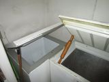 a small white chest freezer in the corner of a room