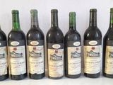 six bottles of wine are lined up in a row on a table
