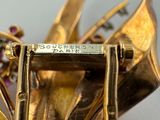 a close up of a gold brooch with flowers on it