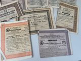 several old certificates are displayed on a table in front of a laptop