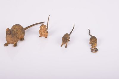 three small metal mice are standing next to each other