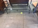 une table basse en verre surmontée d'un piètement en métal