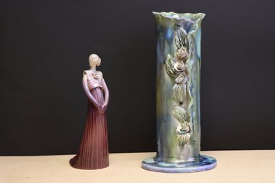 a vase and a figurine sitting on a table