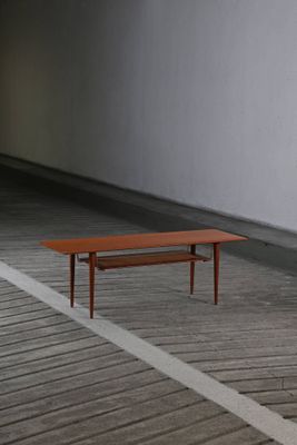 une table basse posée sur un parquet dans une pièce vide