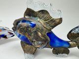 two glass fish figurines sitting next to each other on a table