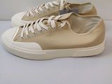 baskets en toile beige avec des lacets blancs sur un fond blanc