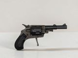 un petit pistolet jouet posé sur une surface blanche, avec un fond blanc