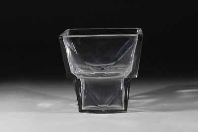 un verre à shot posé sur une table, sur fond noir