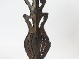 a metal sculpture of a woman holding a bird on a stand