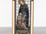 a person holding up a stained glass window with a picture of a man and a woman
