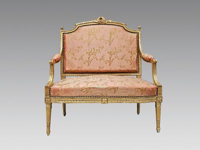 une image représentant un fauteuil rembourré doré et rose sur fond gris