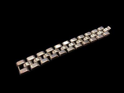 un gros plan d'un bracelet en métal sur fond noir