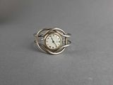 a close up of a silver ring with a clock on it